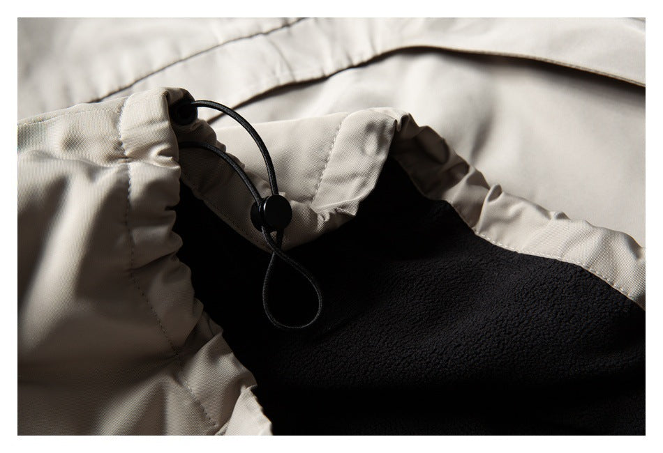 Close-up of a black adjustable drawcord and toggle beside the garment’s black fleece lining.