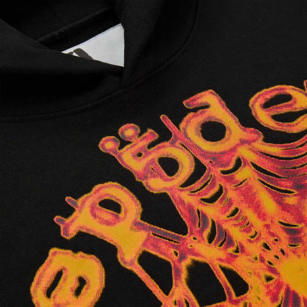 Close-up of the Sp5der Web Graphic Hoodie – Black & Orange 440GSM Heavyweight Streetwear, showing a vibrant yellow-orange spider web graphic text design near the neckline, inspired by its iconic streetwear style.