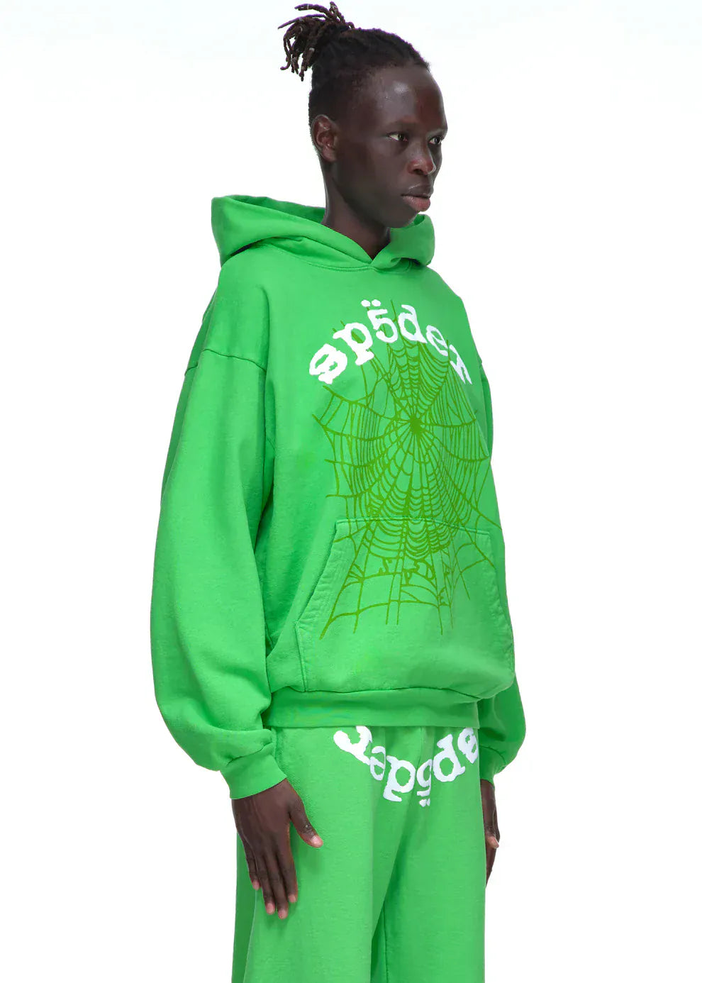 Wearing the Sp5der “Web Core” Hoodie – Neon Green 440GSM Heavyweight Oversized Streetwear Pullover, someone stands out with bold white text, a striking spiderweb graphic, and matching sweatpants for a standout streetwear look.