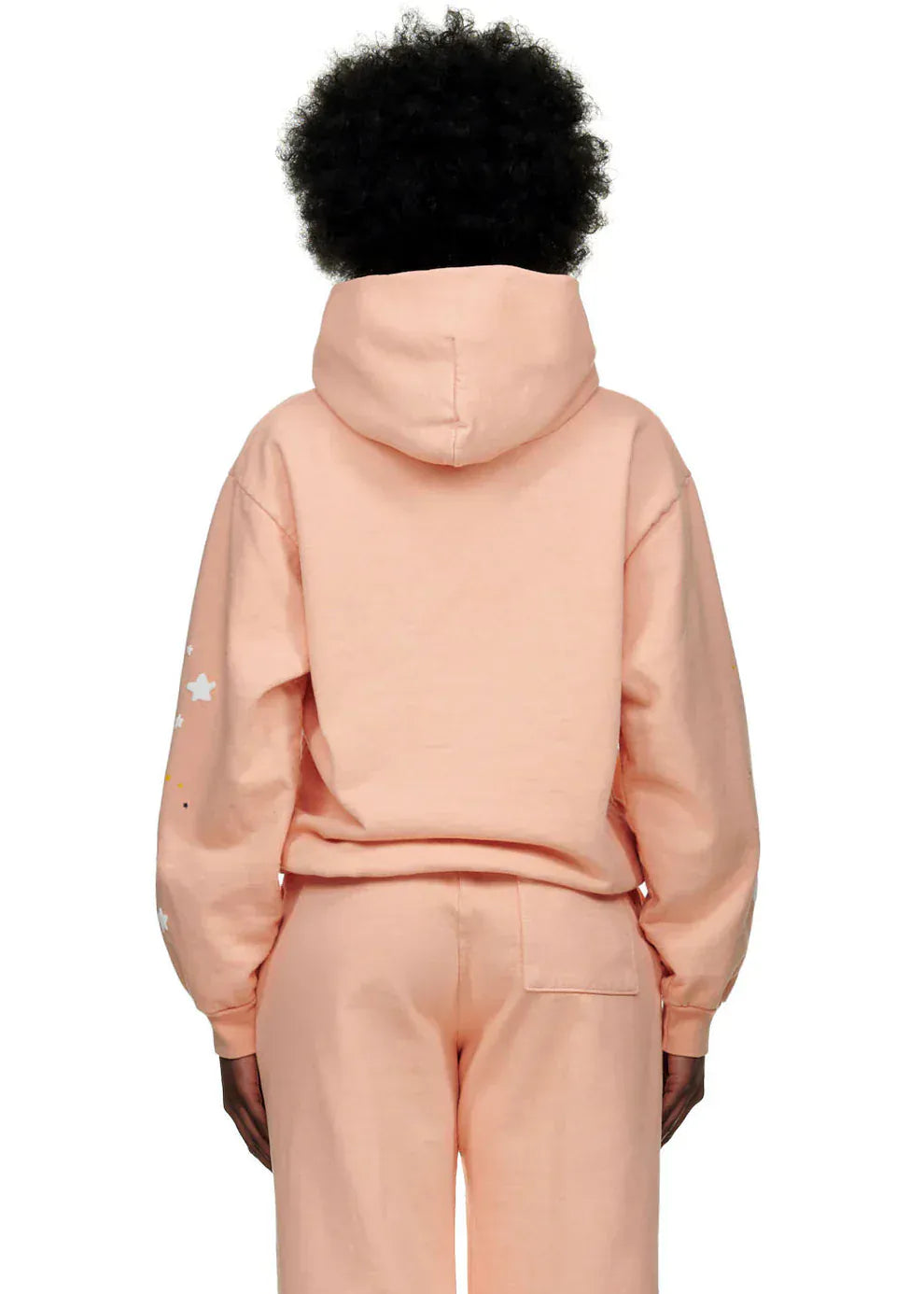 Person stands with their back to the camera, wearing a Peach Pink Sp5der Star Web Hoodie – 440GSM heavyweight oversized streetwear pullover.