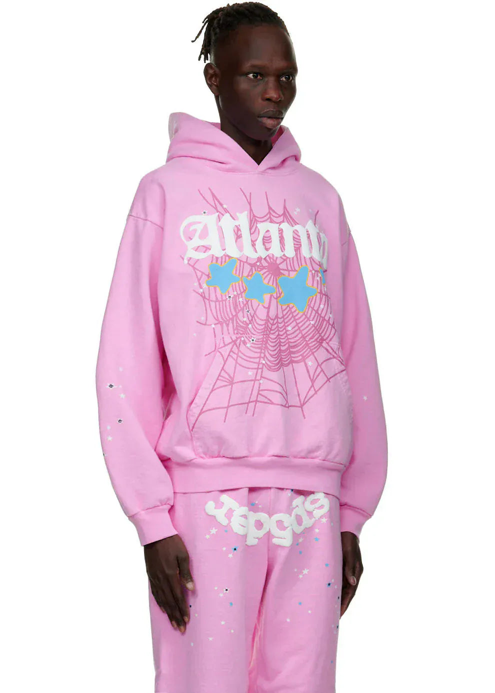 A person wearing the Sp5der Atlanta Hoodie – Pink 440GSM Heavyweight Y2K Streetwear Pullover with graphic designs like a spiderweb, butterflies, and stylized text, capturing bold Y2K streetwear vibes.