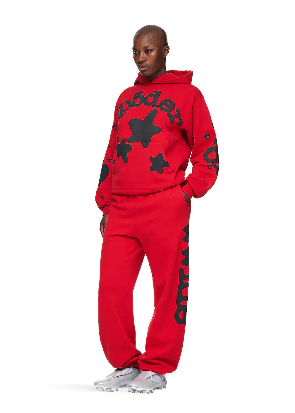 Person wearing a Sp5der “Starfire” Hoodie – Red & Black 440GSM Heavyweight Oversized Streetwear Pullover with matching sweatpants, black star and text graphics, hands in pockets, and white sneakers.