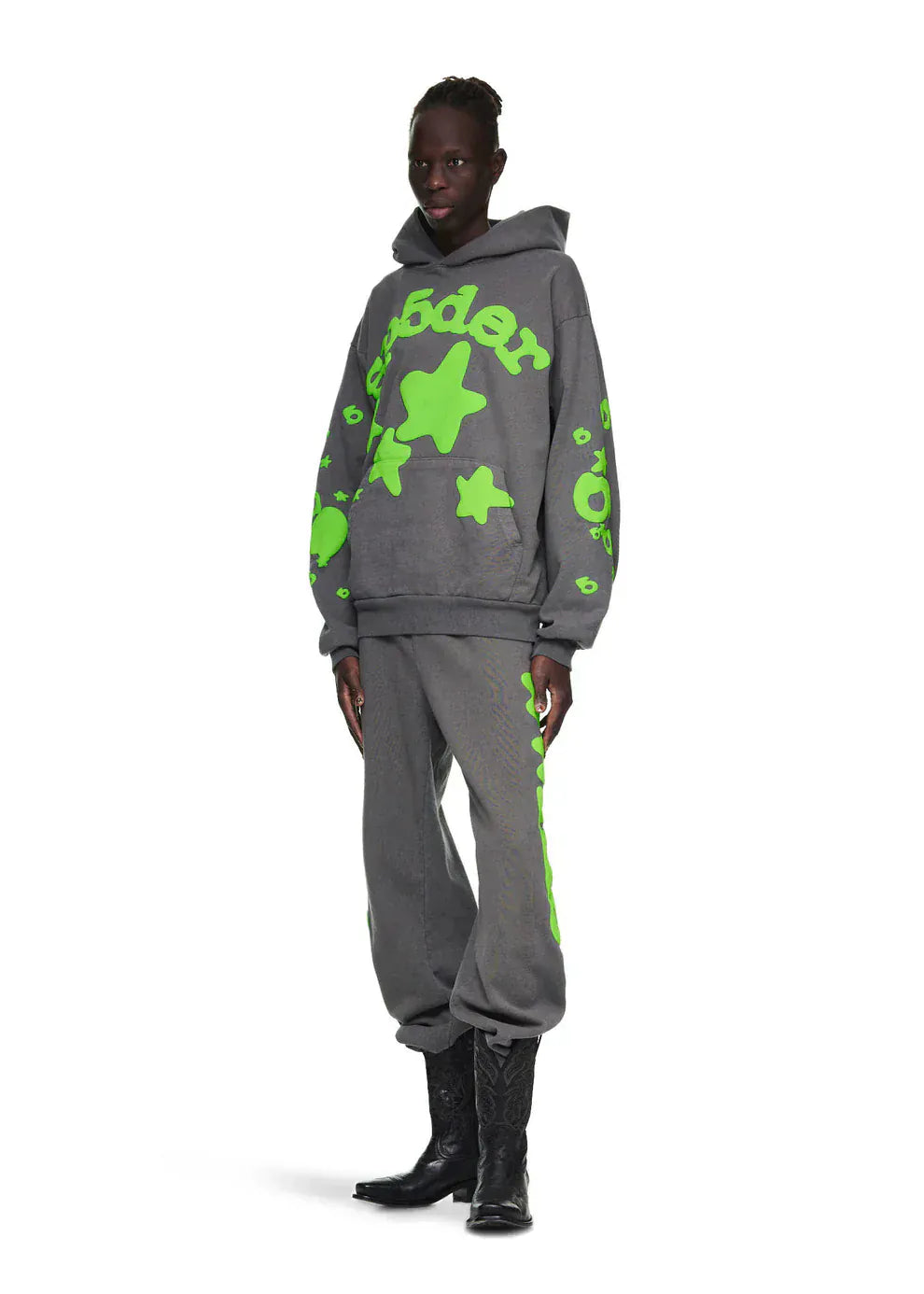 A person wears the Sp5der 440GSM Heavyweight Hoodie – Grey & Neon Green Star Graphic Oversized Sweatshirt with matching sweatpants and black cowboy boots, standing against a white background for a bold streetwear look.