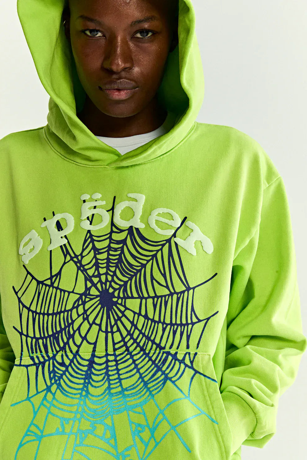 Wearing the Sp5der Web Graphic Hoodie – Neon Green 440GSM, featuring a bold spider web design and "spider" across the chest—a standout heavyweight streetwear piece for making a statement.