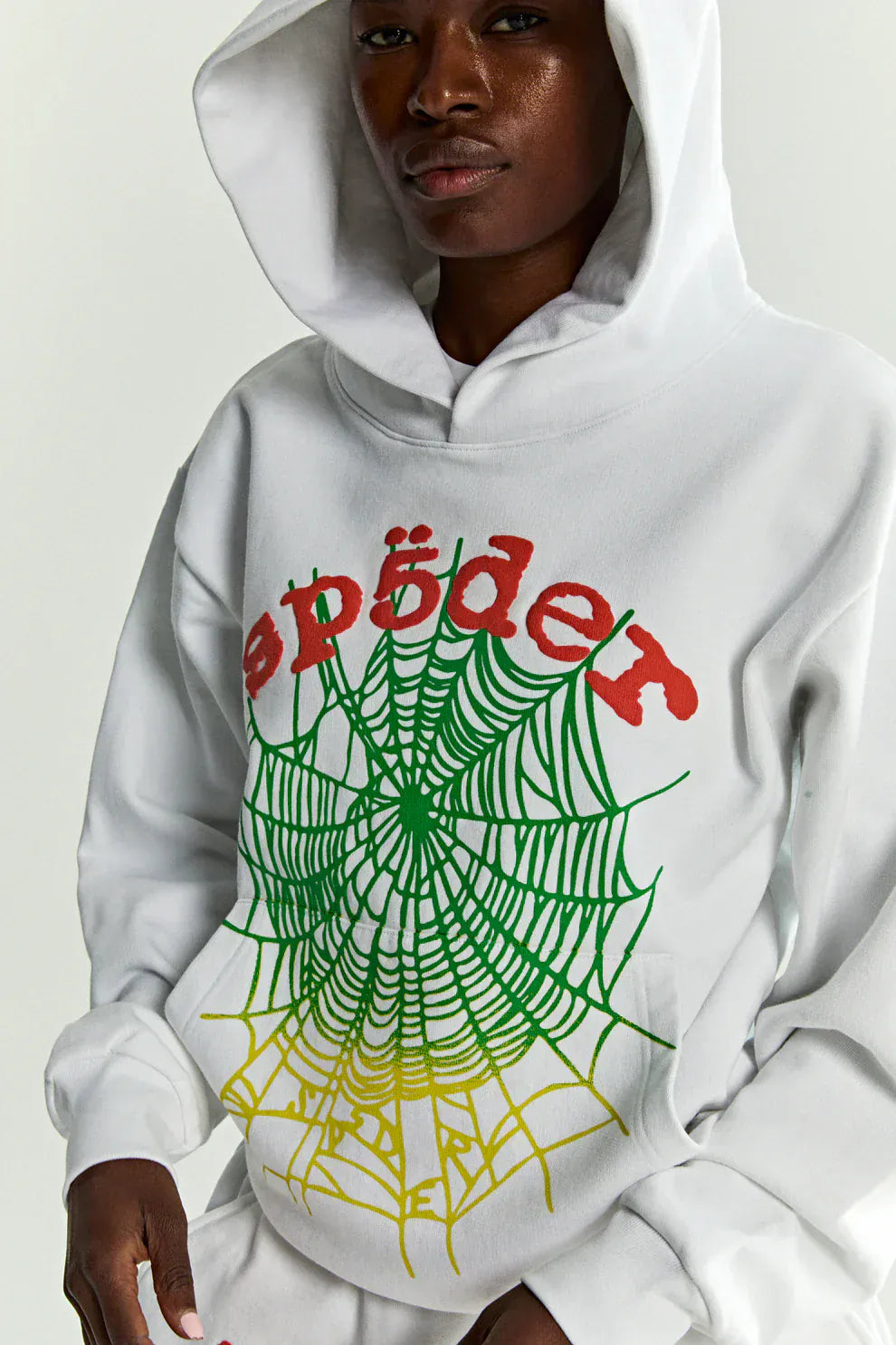 Person wears the Sp5der “Toxic Web” Hoodie—a white & neon lime, 440GSM heavyweight oversized pullover with a striking spiderweb graphic and bold branding, perfect for capturing that standout Y2K streetwear vibe.