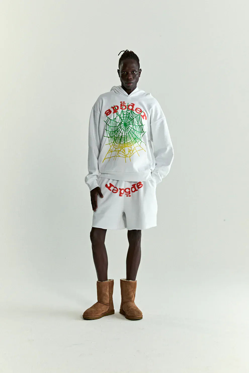 Person wearing the Sp5der "Toxic Web" Hoodie – White & Neon Lime 440GSM Heavyweight Oversized Streetwear Pullover, styled with matching white shorts and brown boots, evoking Y2K streetwear vibes against a plain white background.