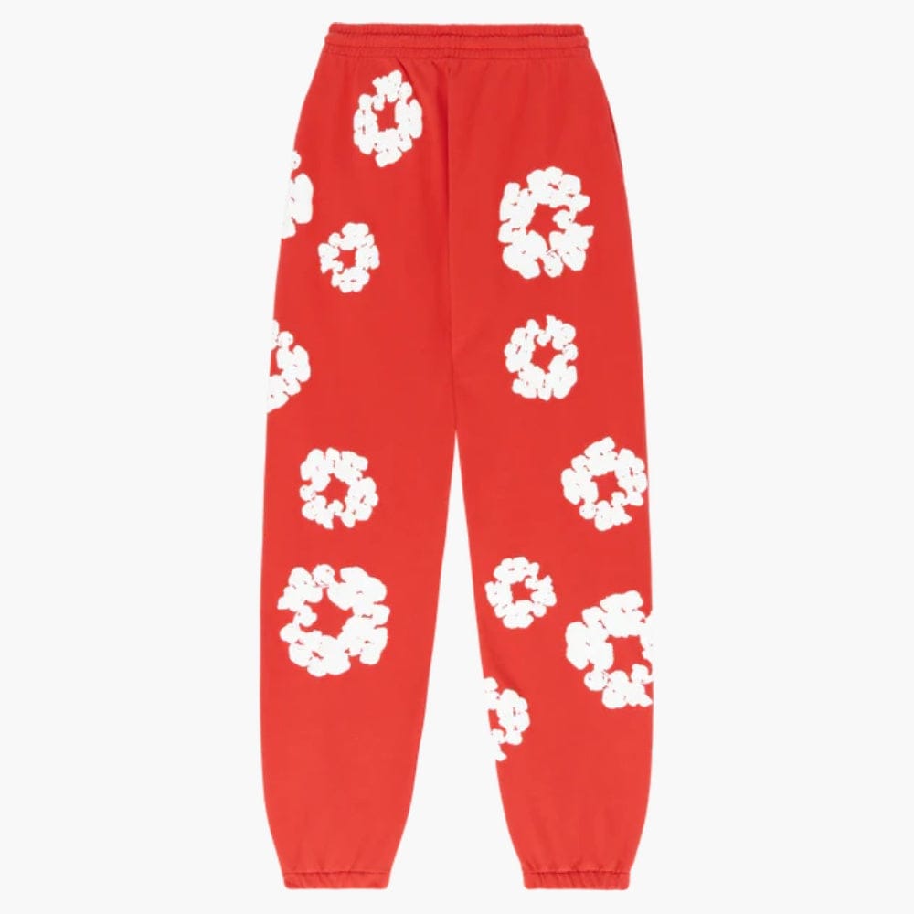 The Red “Cotton Wreath” Denim Tears Sweatpants feature a white floral print, elastic waistband and cuffs—ideal for adding bold streetwear flair to your outfit.