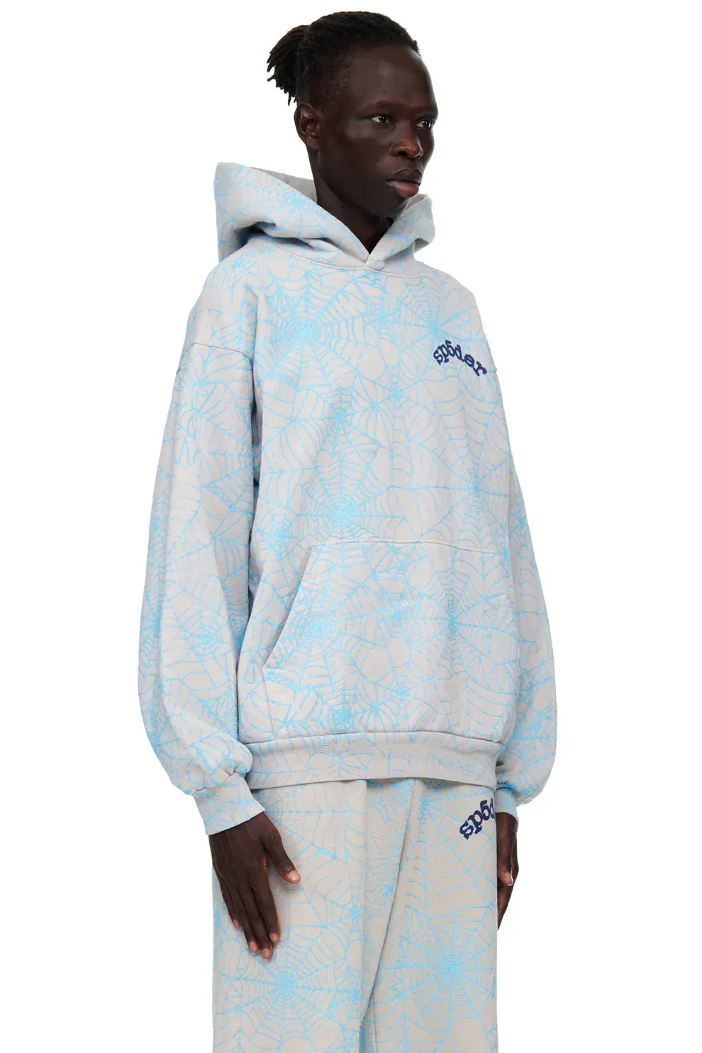 Person wearing the Light Grey All-Over Spider Web Graphic Hoodie – Comfort Fit Pullover Hoodie, featuring a blue spiderweb graphic and blue embroidered text, standing against a plain white background.