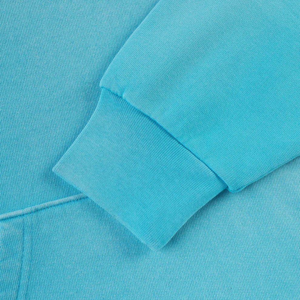 Close-up of the sleeve and cuff of the Turquoise Graphic Hoodie with Star Detail, featuring soft, textured fabric and a spider web back print. Comfort fit pullover hoodie.
