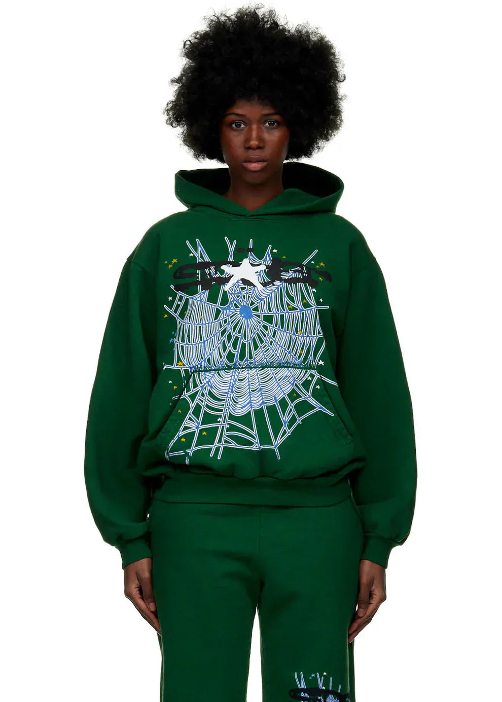 A person with an afro hairstyle sports the Dark Green Graphic Hoodie with Spider Web Print – Comfort Fit Pullover Hoodie for Everyday Wear, paired with matching green pants for a standout streetwear look.