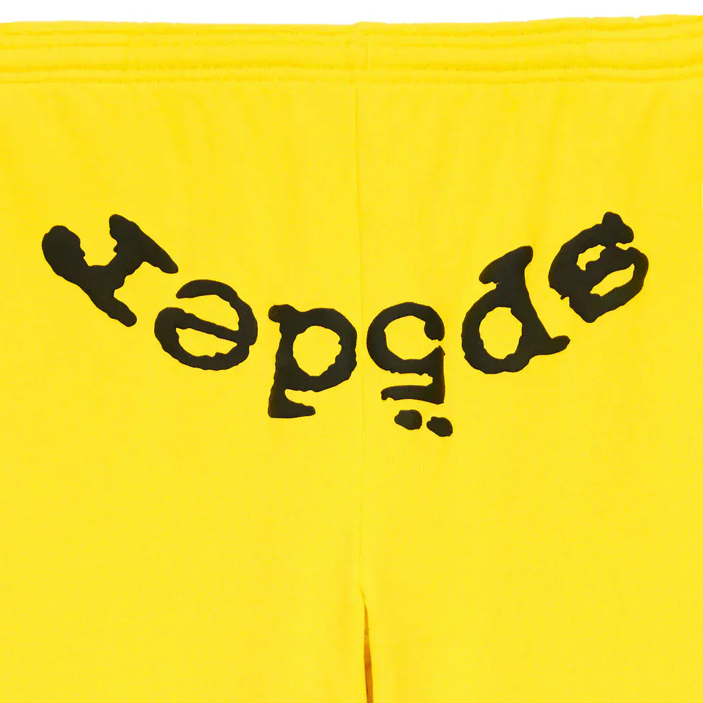 Unisex yellow cotton Sp5der Sweatpants featuring a bold black "despair" logo printed upside down and mirrored across the front—streetwear-inspired joggers with unique, eye-catching style.