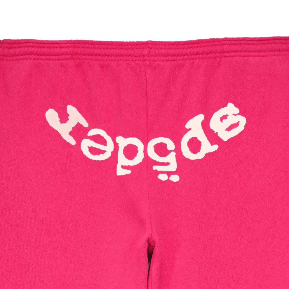 Close-up of Sp5der Sweatpants—unisex pink cotton joggers with a bold white front logo print, styled for standout streetwear appeal.