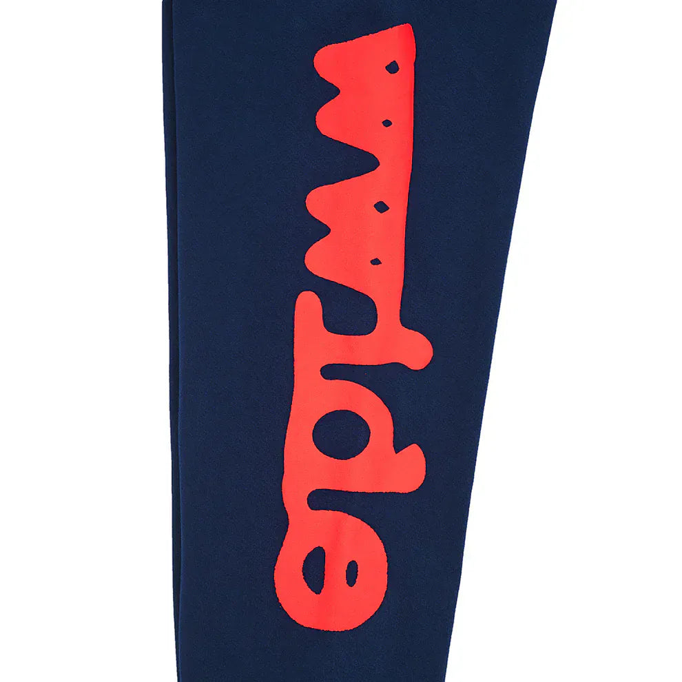 The Sp5der Sweatpants Navy Blue Red Side Logo Print are 100% cotton streetwear jogger pants, featuring a navy blue fabric with a bold red logo printed vertically along the side.