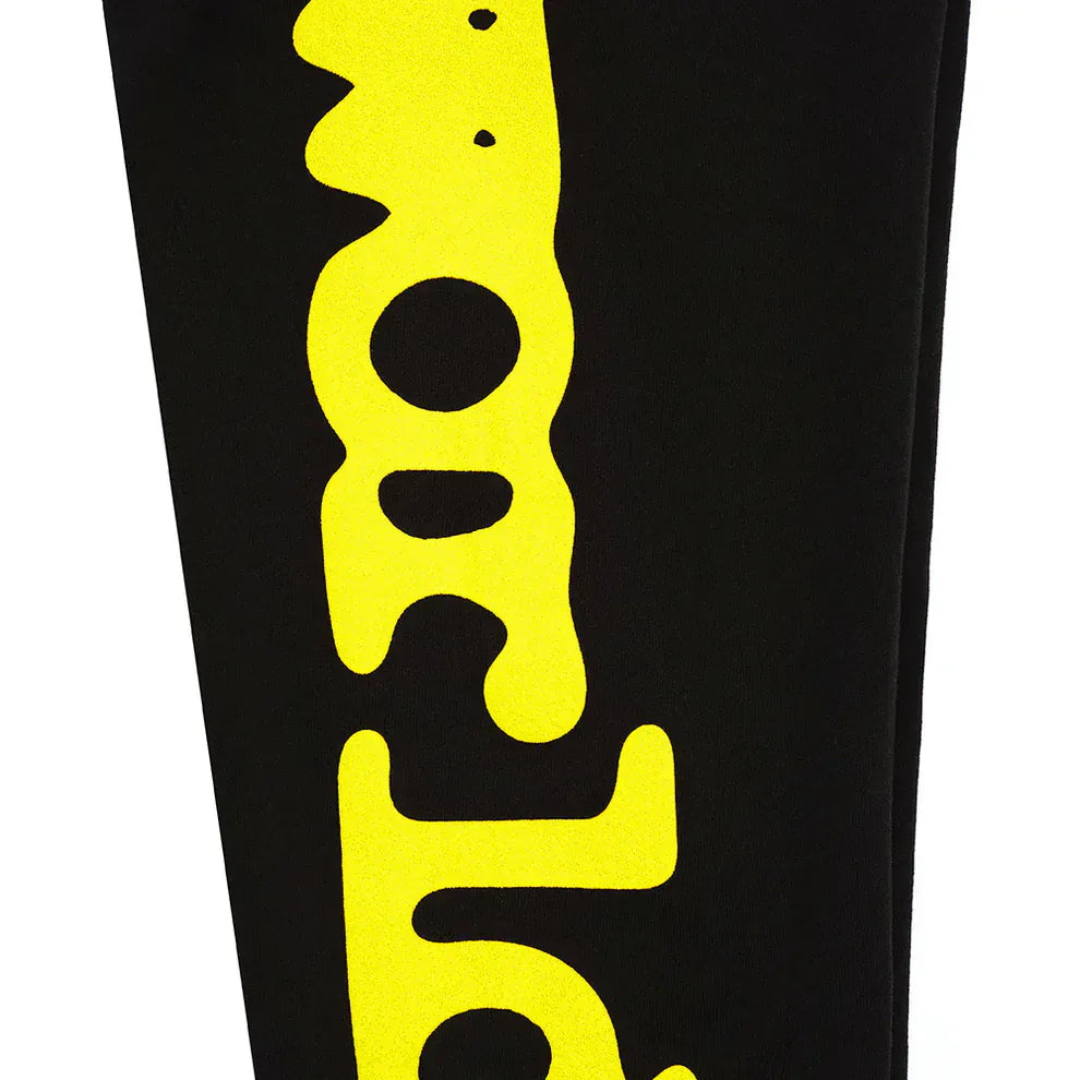 The Sp5der Sweatpants Black Yellow Side Logo Print feature bold yellow, dripping-style lettering down the leg on black 100% cotton jogger pants, delivering a unique streetwear vibe.