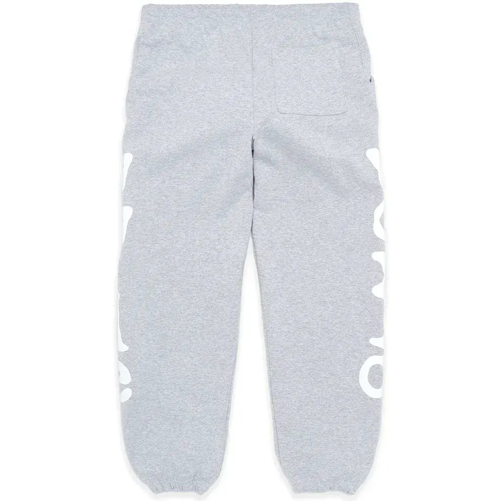 The 100% Cotton Sp5der Sweatpants for Men are grey streetwear jogger pants with a relaxed fit, elastic cuffs, a single back pocket, and large white graphic print on the sides.