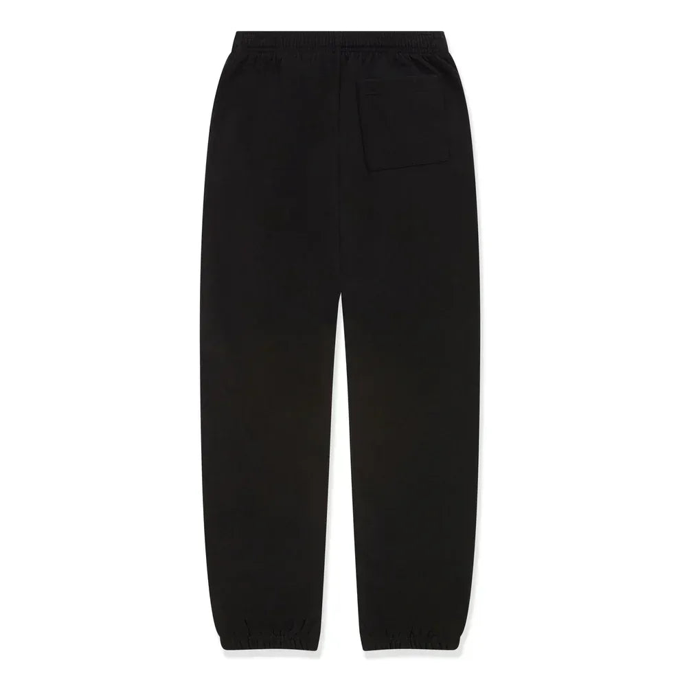 Unisex black Sp5der jogger pants made from 100% cotton, featuring pink logo graphics, a relaxed fit, elastic waistband and cuffs, plus a back pocket. Perfect for streetwear style. Displayed flat on a white background.