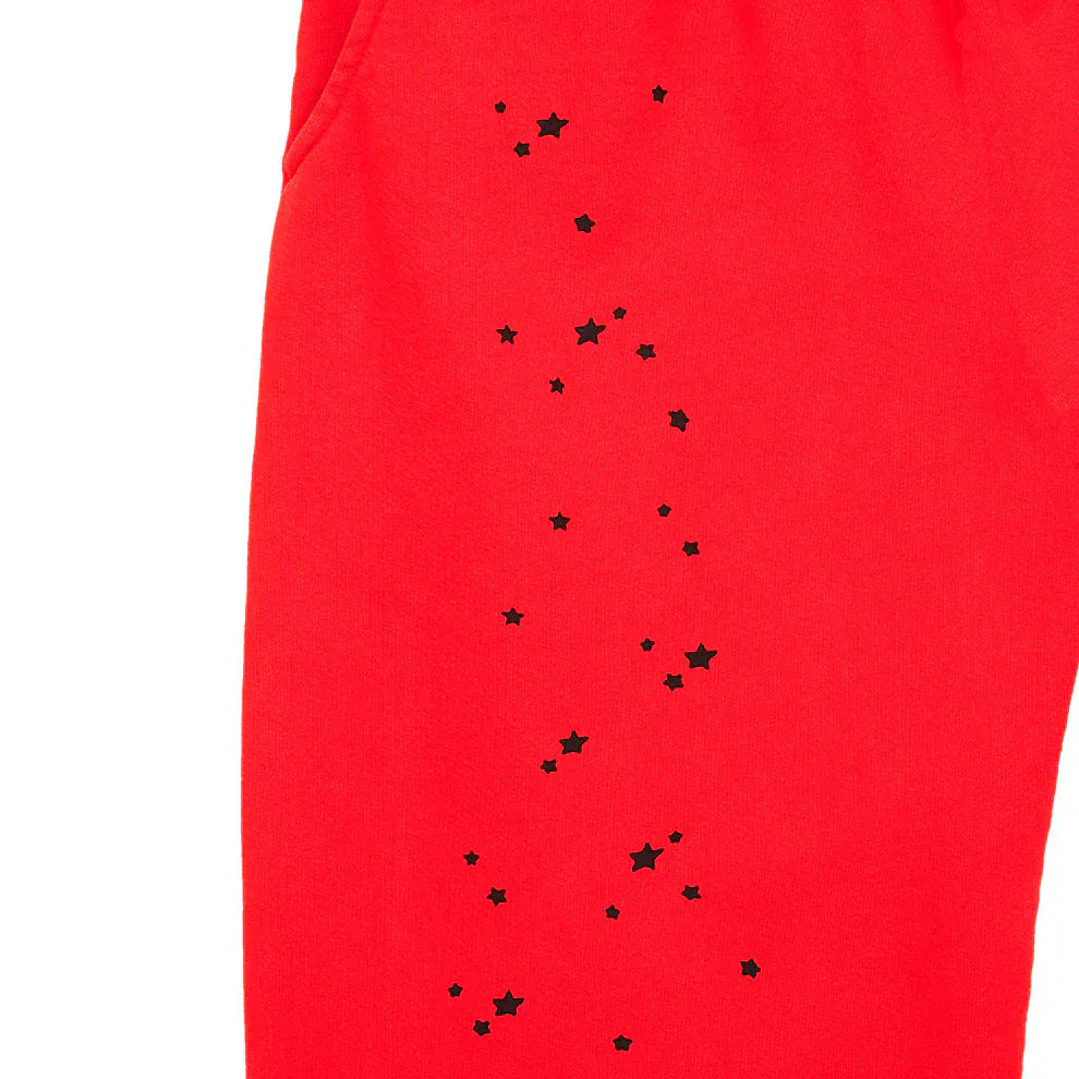 Close-up of 100% cotton Sp5der Sweatpants—unisex red jogger pants with black logo and star graphics in a relaxed fit, ideal for streetwear style.
