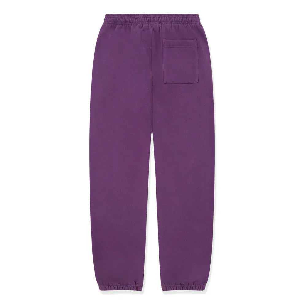Unisex 100% cotton Sp5der sweatpants in purple, featuring a yellow logo and star graphics, relaxed fit, elastic waistband and cuffs, single back pocket—perfect streetwear joggers laid flat on a white background.