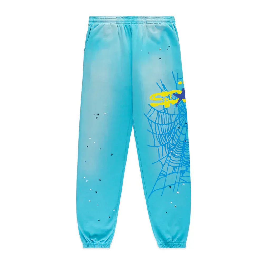 100% cotton Sp5der sweatpants in blue, unisex jogger style with a spider web graphic and star details. Features a relaxed fit, elastic waistband, and cuffs for comfortable streetwear.