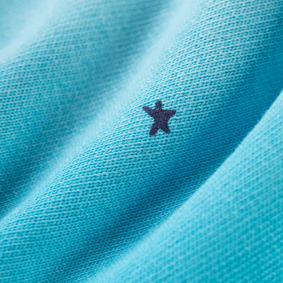 Close-up of the 100% Cotton Sp5der Sweatpants—unisex blue joggers with a spider web graphic and star details. Made from soft cotton in a relaxed fit for streetwear style.