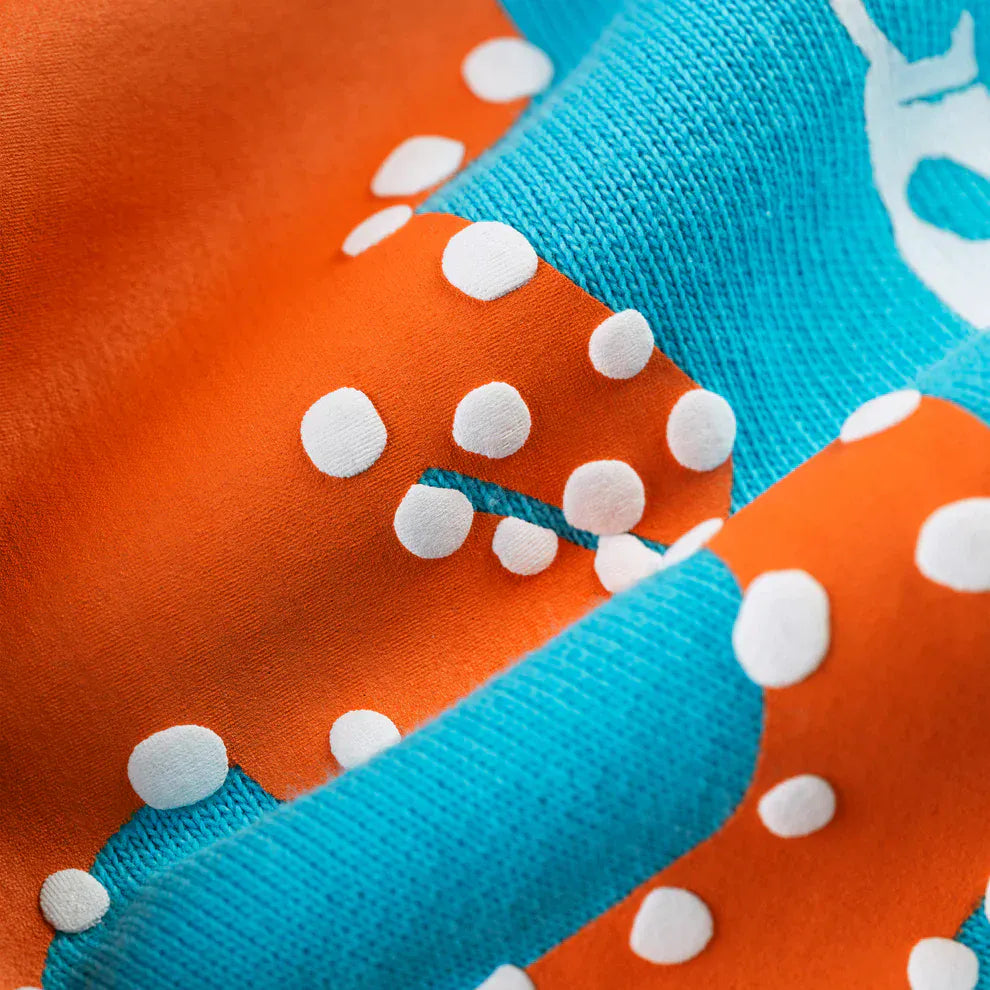 Close-up of 100% Cotton Sp5der Sweatpants – Unisex Teal Jogger Pants with orange logo print, highlighting the textured fabric and relaxed fit.