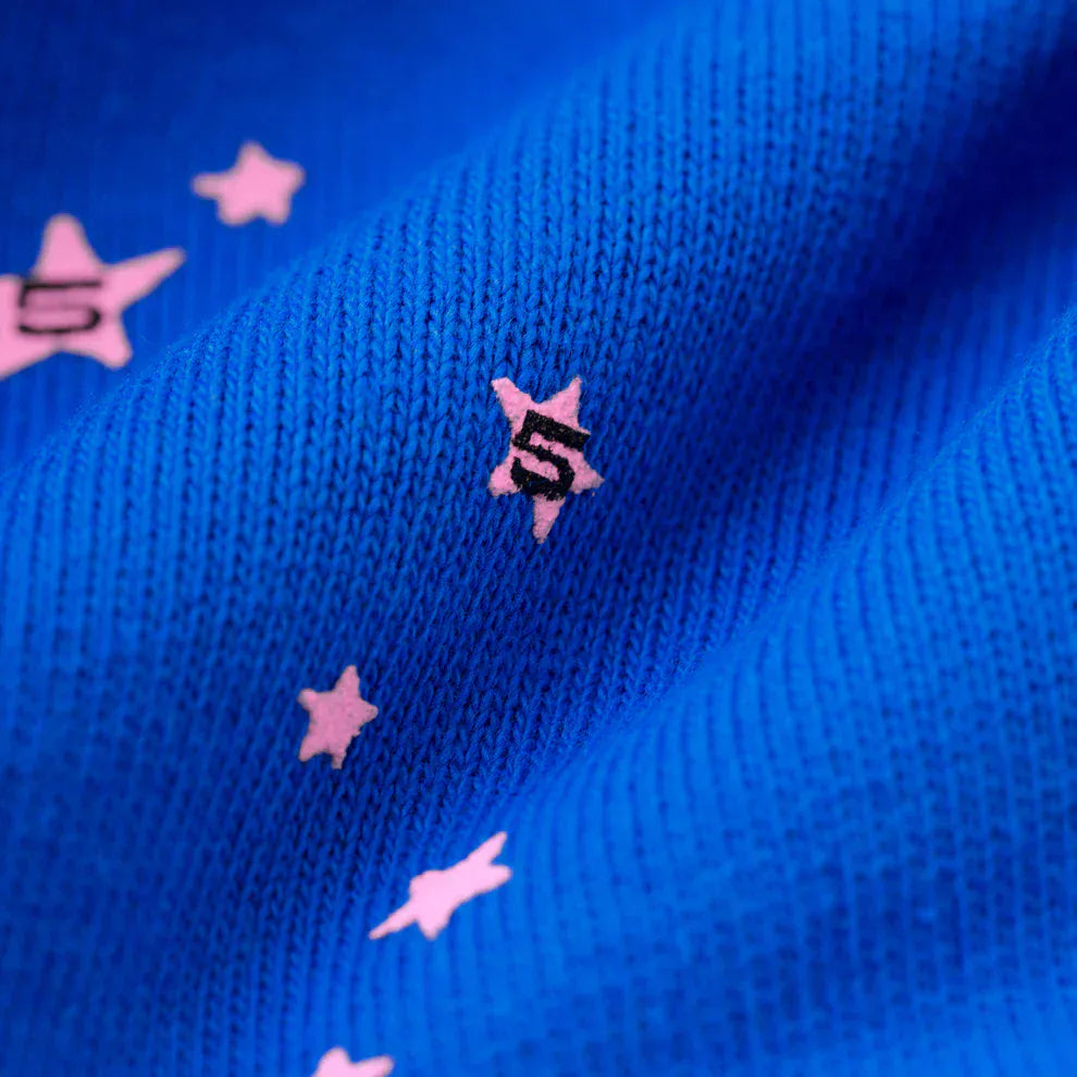 Close-up of 100% Cotton Sp5der Sweatpants—Unisex blue jogger pants with pink logo and star accents in a relaxed fit. A playful, stylish choice for streetwear that adds standout detail to any casual look.