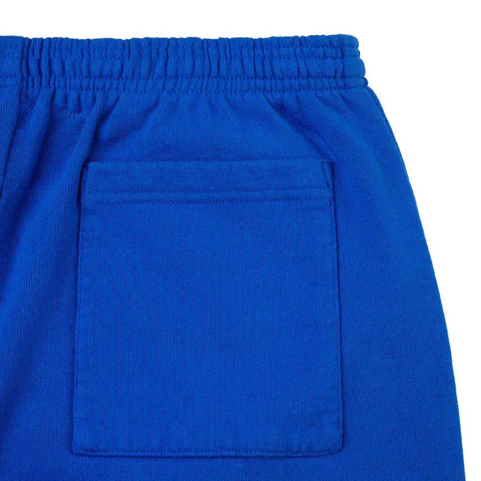 Close-up of 100% cotton Sp5der sweatpants in bright blue, featuring a pink logo, star accents, elastic waistband, and back pocket. These unisex jogger pants offer a relaxed fit—perfect for streetwear style.