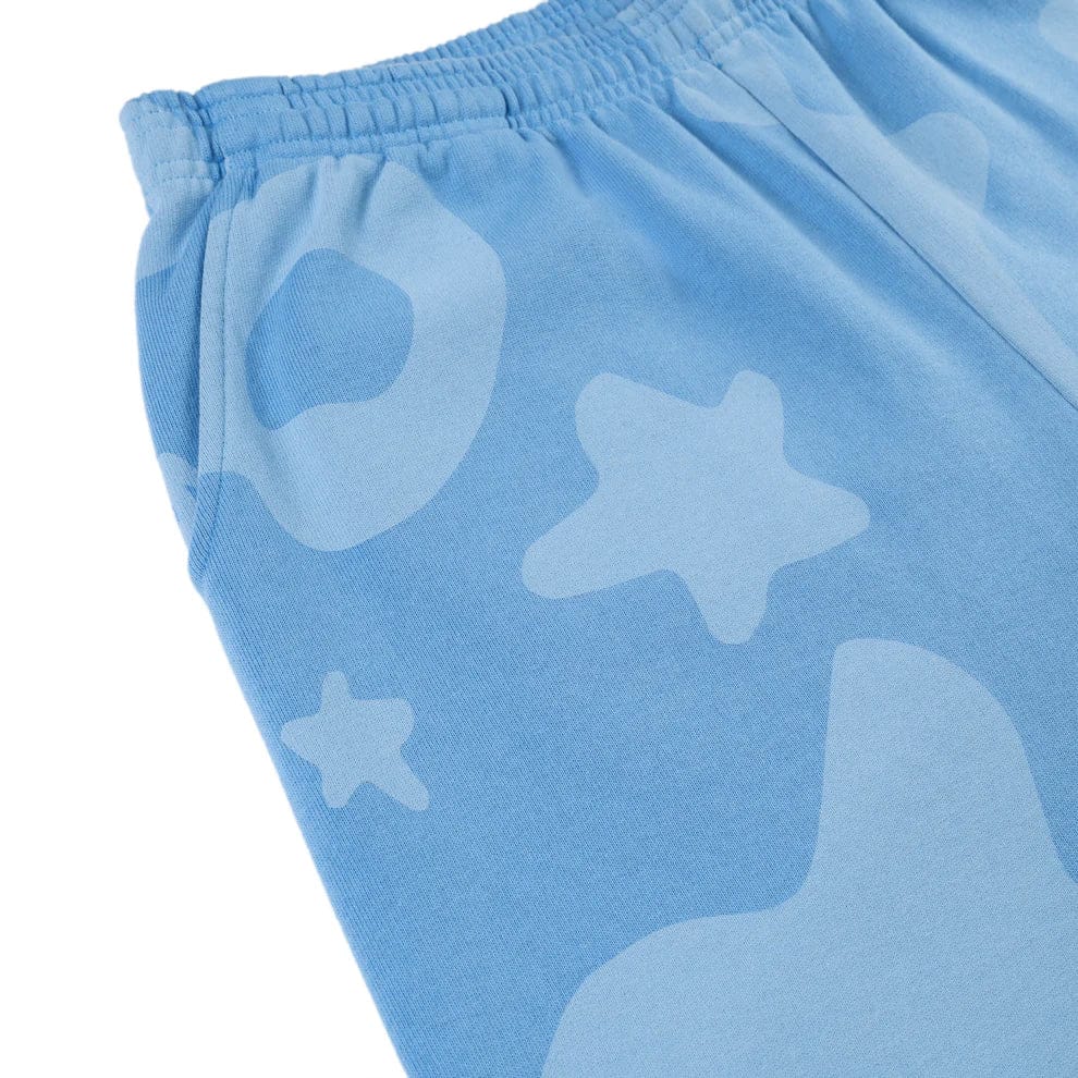 Close-up of Sp5der Light Blue All-Over Print Sweatpants, 100% cotton unisex streetwear joggers with an elastic waistband and abstract star and circle patterns.