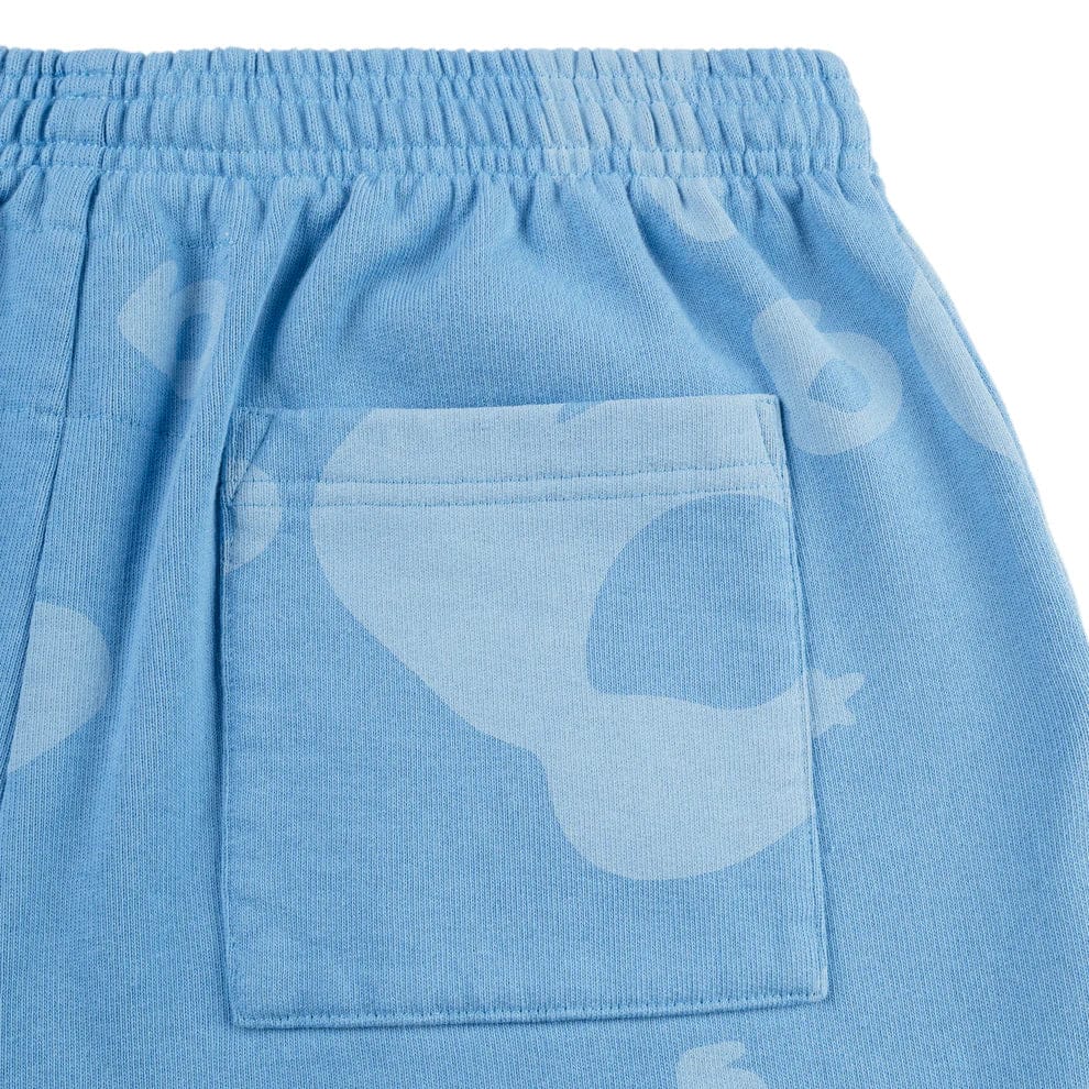 Close-up of the Sp5der Light Blue All-Over Print Sweatpants—unisex 100% cotton streetwear joggers with an elastic waistband, square patch pocket, and subtle white abstract pattern.