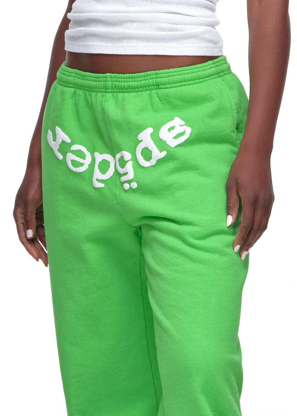 A person wears Sp5der Sweatpants – unisex green cotton sweatpants with a front logo print—paired with a white ribbed tank for an eye-catching streetwear jogger look.
