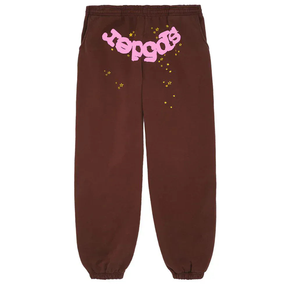 Unisex brown cotton Sp5der Sweatpants feature an elastic waistband and cuffs, pink front logo, and star print for a streetwear look that blends comfort with standout style.