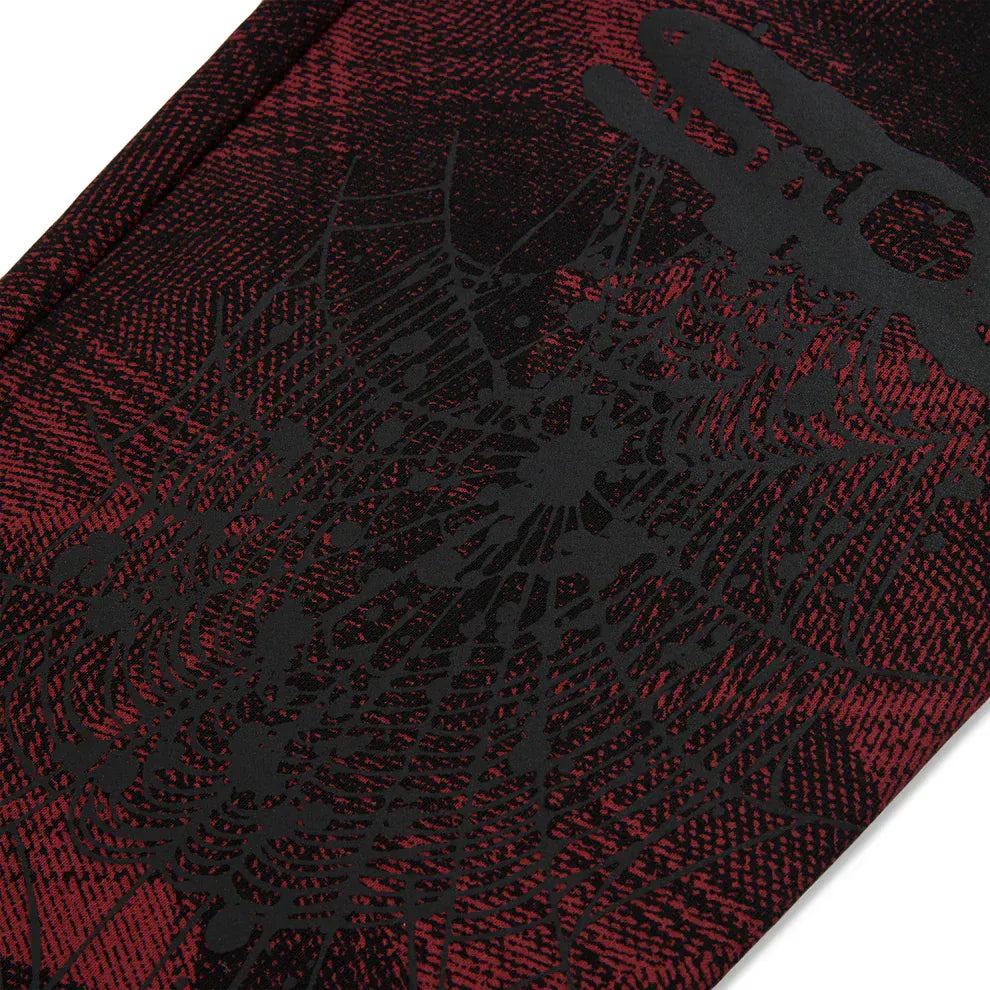 Close-up of Sp5der Sweatpants – Unisex Red and Black Patterned Cotton Sweatpants with graphic detail, showcasing bold streetwear joggers style.