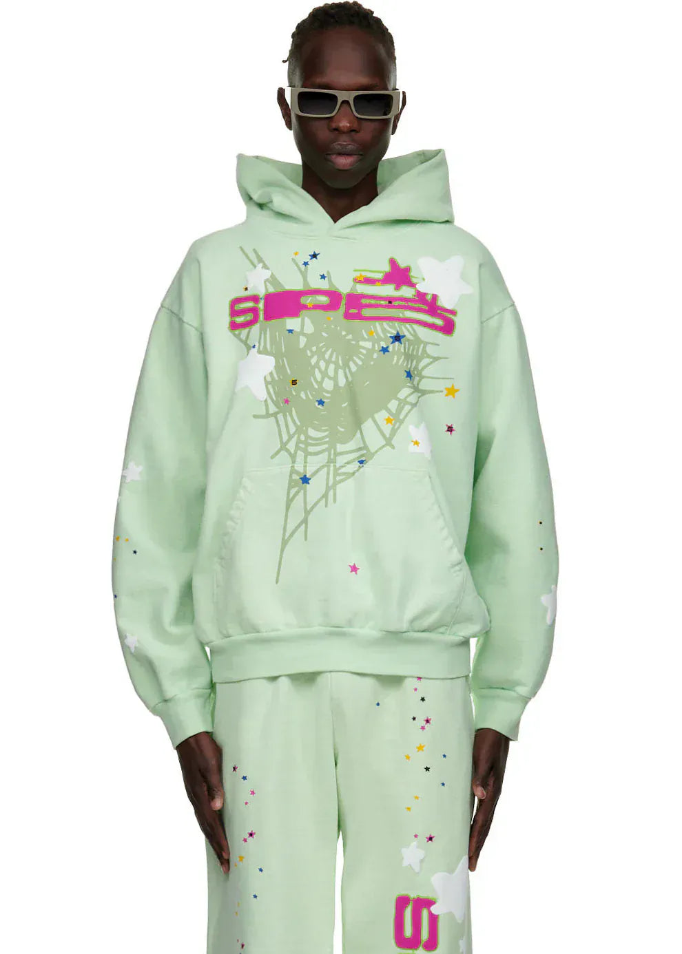 Wearing the Sp5der “Mint Star Web” Hoodie – a mint green, 440GSM heavyweight oversized streetwear pullover – this look channels Y2K vibes against a plain background.
