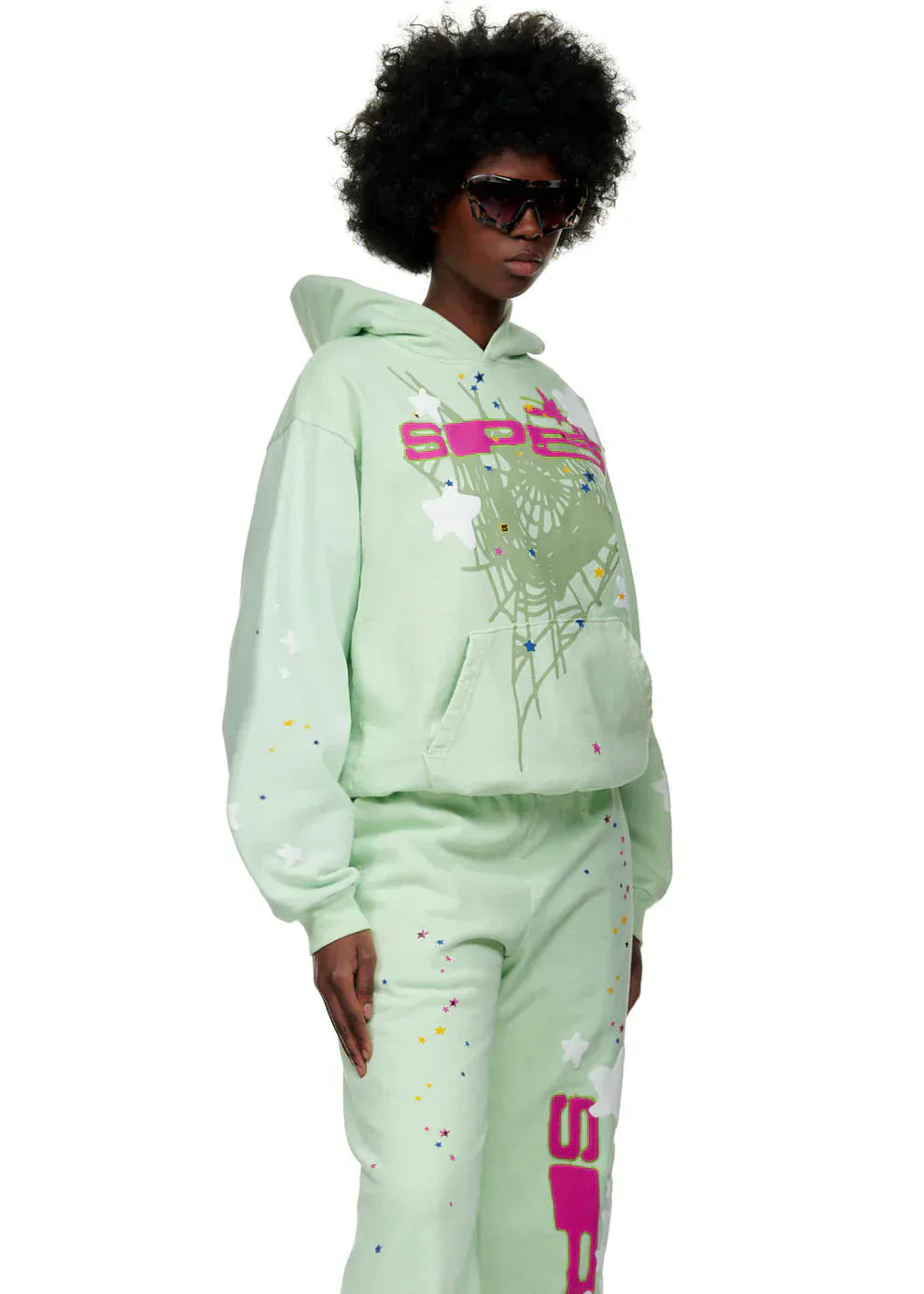 Person wearing a Sp5der “Mint Star Web” Mint Green Hoodie—440GSM heavyweight, oversized streetwear pullover—paired with matching pants and bold graphics for a standout Y2K vibe, complete with large dark sunglasses.