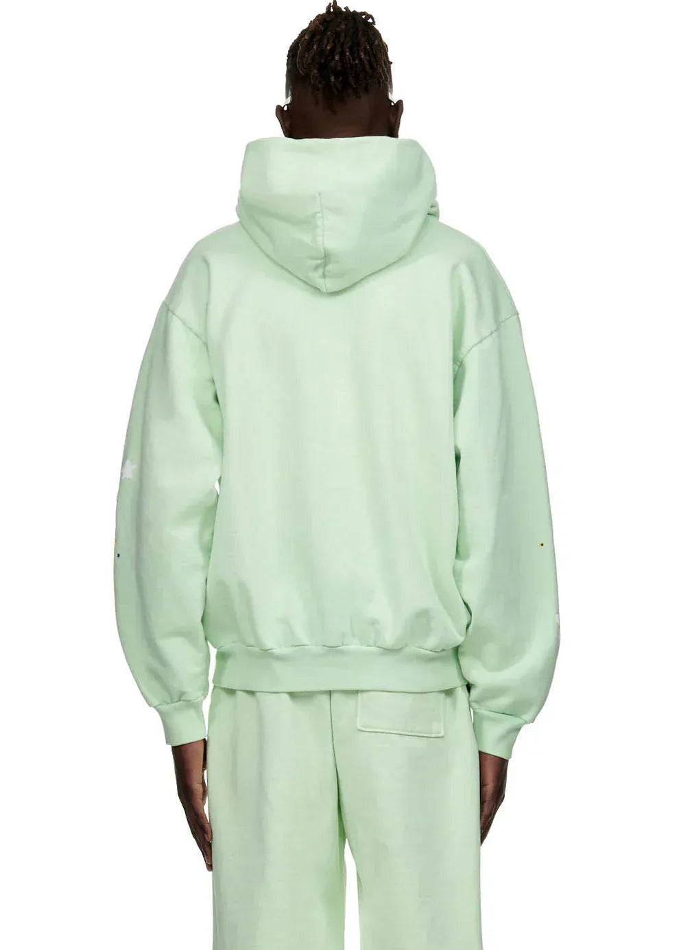 Person wearing a Sp5der “Mint Star Web” Hoodie – Mint Green 440GSM heavyweight oversized streetwear pullover and matching sweatpants, back to camera. This unisex hoodie brings effortless Y2K street style in a fresh mint shade.