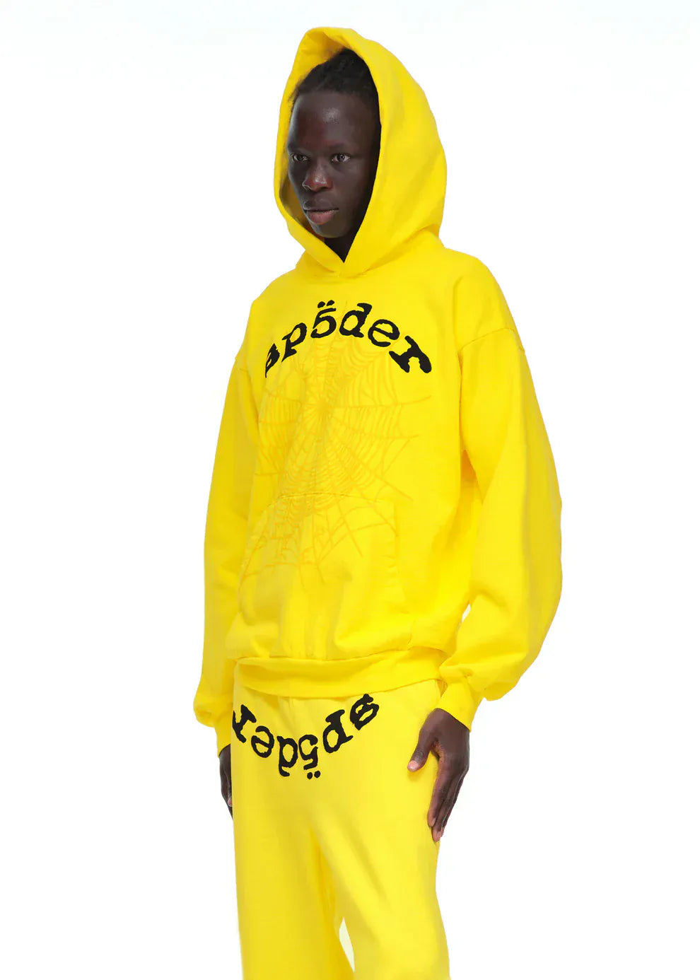 Sporting the Yellow Graphic Hoodie with Spider Web Print and Lettering – Comfort Fit Pullover Hoodie, this look captures eye-catching streetwear style with bold spider web details and standout lettering.