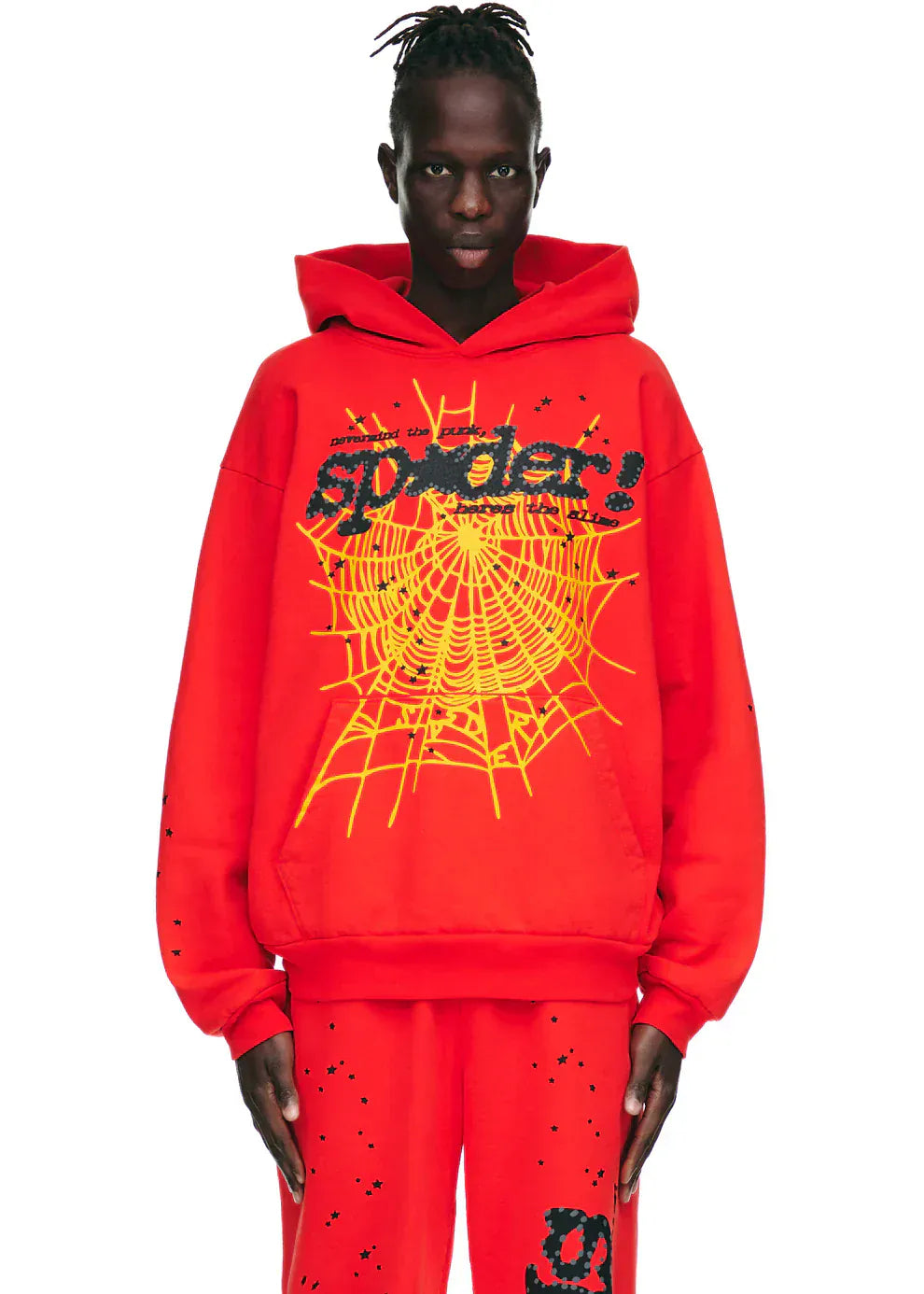 Wearing the Red Graphic Hoodie with Spider Web Print and Star Details, this person stands against a white background, showcasing a bold comfort fit pullover hoodie as part of their streetwear look.