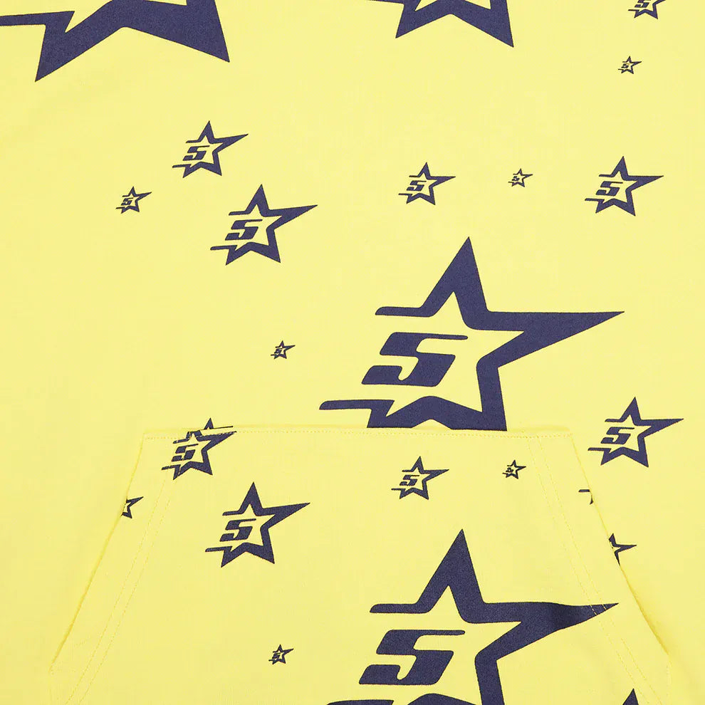 The Yellow All-Over Star Graphic Hoodie is a comfort fit pullover featuring navy blue outlined star prints, some with the number 5, and a visible front pocket.