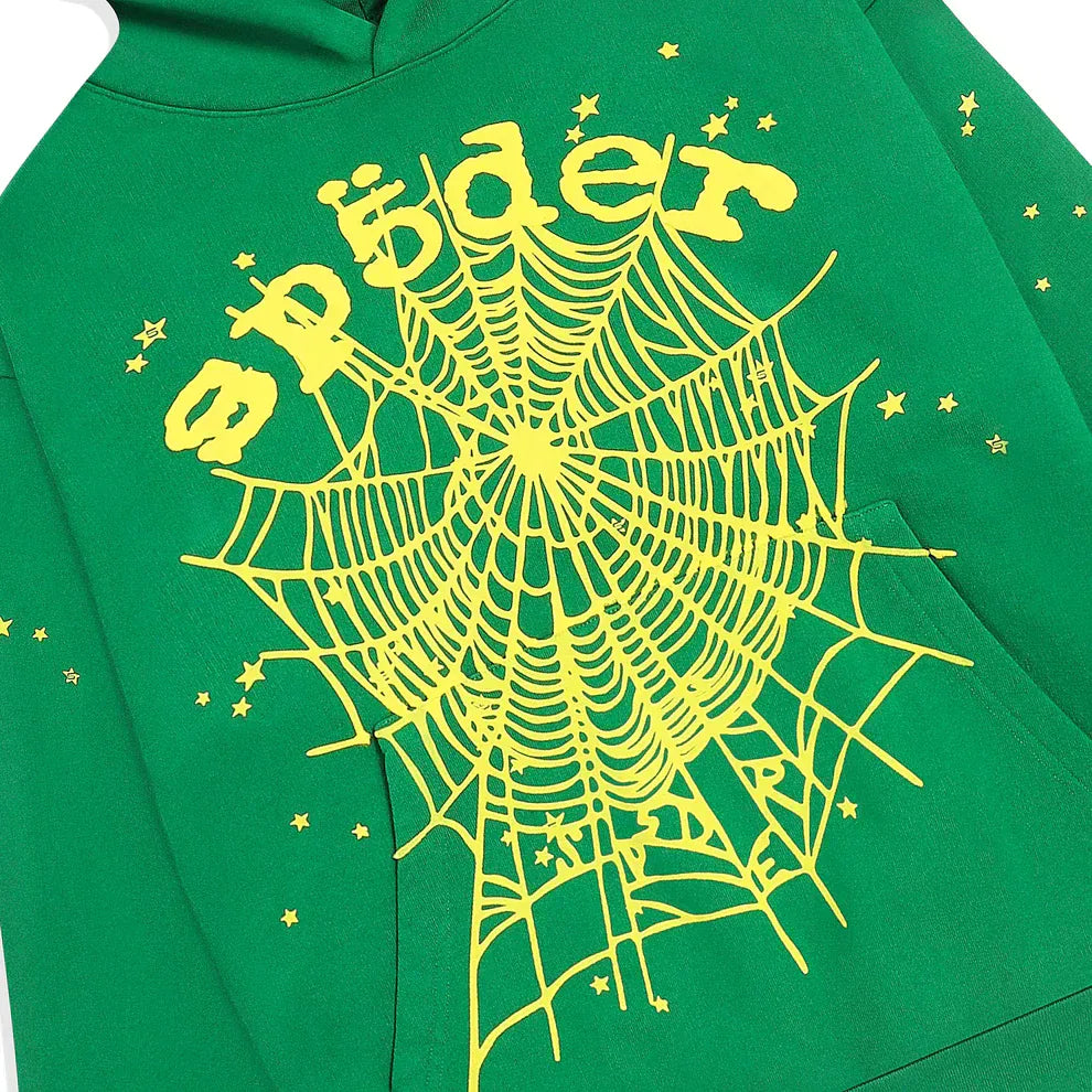 The Sp5der Web Hoodie in emerald green and yellow features a large yellow spiderweb and bold "Sp5der" lettering on the front, accented by small stars. This 440GSM heavyweight oversized pullover is a standout streetwear essential.