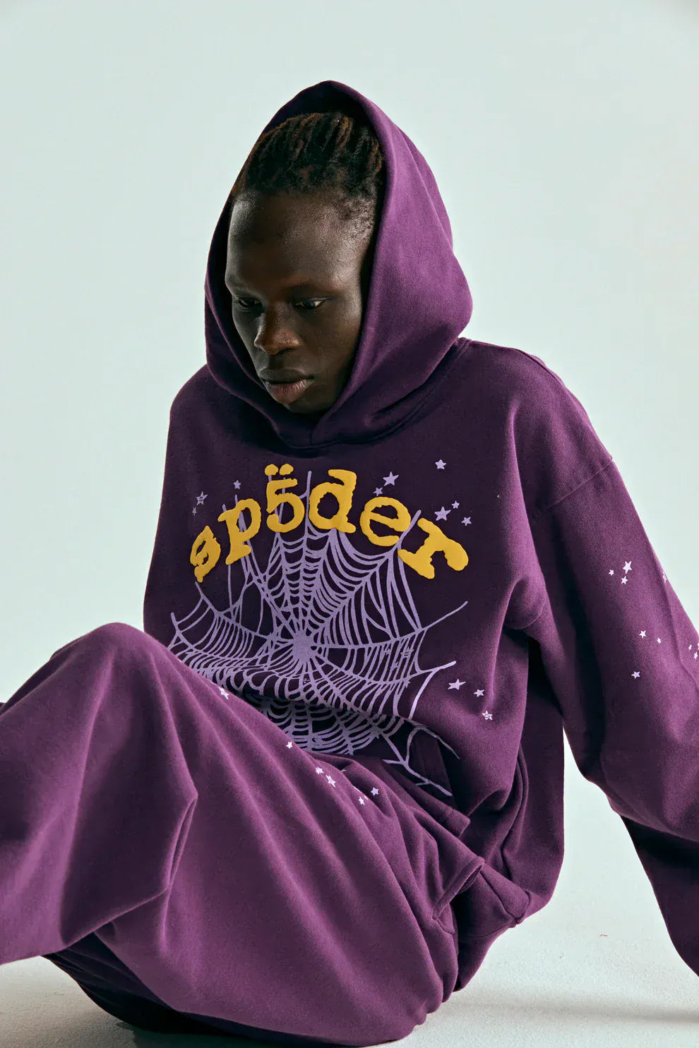 Person wearing a Sp5der Web Hoodie – Deep Purple & Yellow 440GSM Heavyweight Oversized Streetwear Pullover, featuring "sp5der" text and spiderweb graphics, exuding luxury streetwear vibes against a plain background.